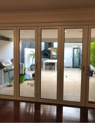 Sliding glass doors leading to a patio area with a dining table and barbecue.